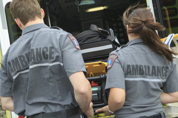 Paramedic employee with ambulance in the background.