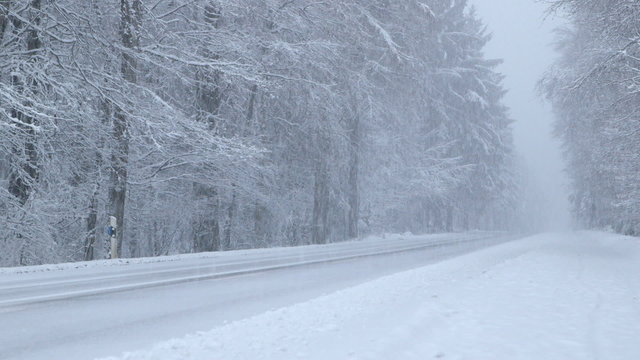 Heavy Snowfall on a Mountain Road at Dusk
