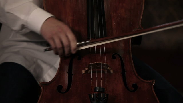 Close up pan shot of a cello player