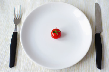 tomato served on plate with fork and knife