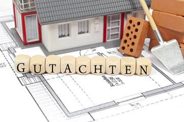 Bauplan mit Ziegelstein und Haus mit Gutachten