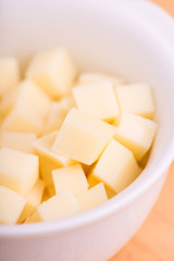cheese cubes close up on wooden background - selective focus