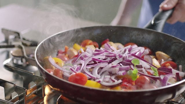 Frying vegetables and chicken white meat.