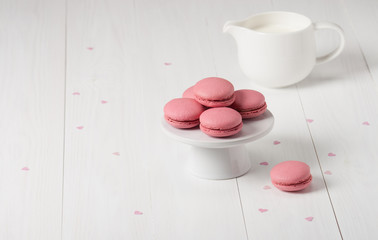 Obraz na płótnie Canvas Macaroons Biscuits On White Stand. Paper Hearts