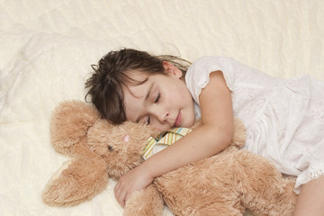 Девочка спит с мягкой игрушкой