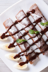 chocolate pancakes with sauce close-up vertical top view