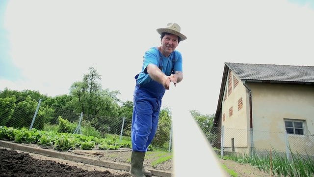 Gardener rakes the soil in the garden shot from the rakes perspective