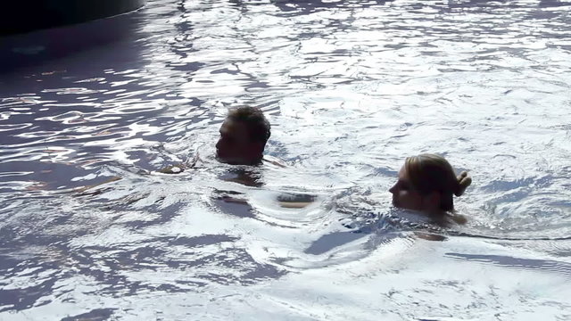 yound couple swimming in pool and having fun