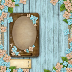 Blue wooden background with a frame, flowers, pearls and lace