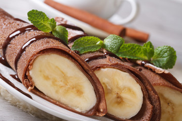 Chocolate crepes with banana filling close-up horizontal