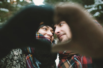 Young hipster couple holding hands in love symbol