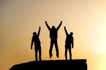 Silhouette of the team on the peak of mountain