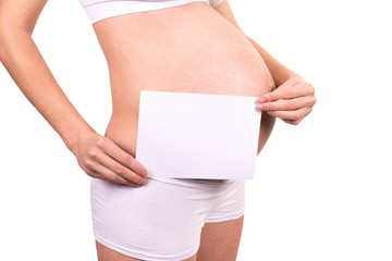 Happy beautiful pregnant woman holding empty white paper