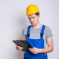 Arbeiter im Blaumann mit Klemmbrett