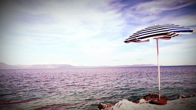 Alone beach retro style umbrella on the mediterranean shore
