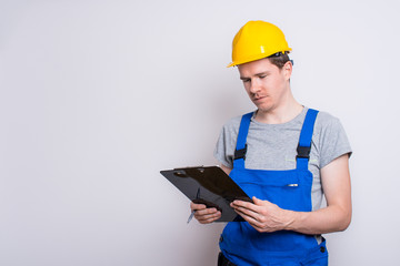 Arbeiter im Blaumann mit Klemmbrett