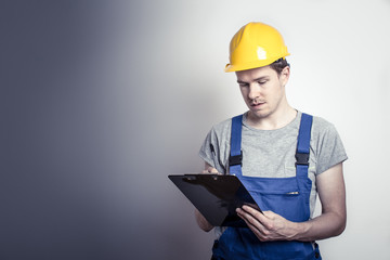 Arbeiter im Blaumann mit Klemmbrett