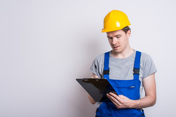 Arbeiter im Blaumann mit Klemmbrett