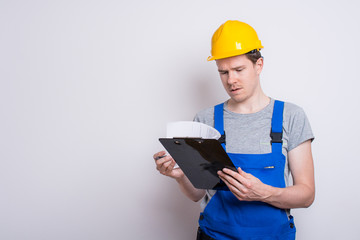 Arbeiter im Blaumann mit Klemmbrett
