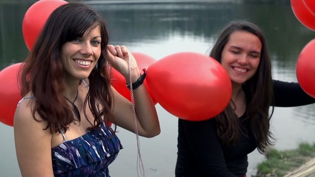 Two Elegant Ladies With Red Balloons At Lake Enjoy Life