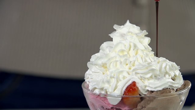 Detail of adding chocolate on the top ice cream cup