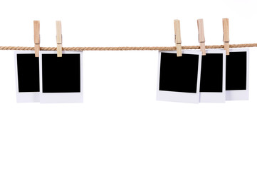 Several blank polaroid style instant photo prints on a rope string or clothesline white background isolated
