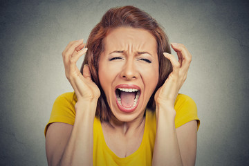 Headshot angry woman screaming hysterical grey background 