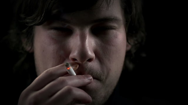 Face of a young man during inhaling a cigarette
