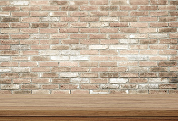 Empty wooden table over brick wall.