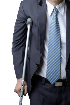 injured businessman with crutches, insurance concept