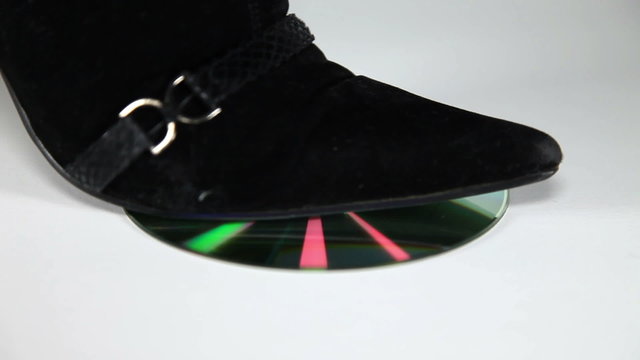 Shot of a womans leg in high heels steping on cd