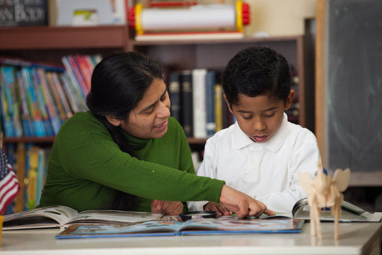 HIspanic Mom And Boy In Home-school Setting Studying Rocks