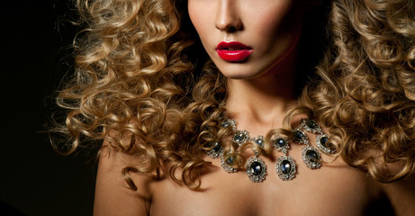 Beautiful woman with magnificent curly hair. Red lipstick. Neckl