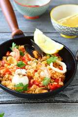 Paella with prawns, mussels and Lemon in a frying pan