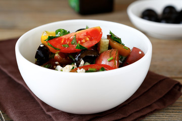 Salad with tomatoes, olives and cheese in a bowl