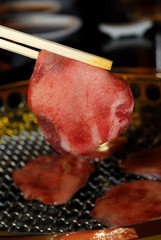 beef tongue sliced holding with chopsticks