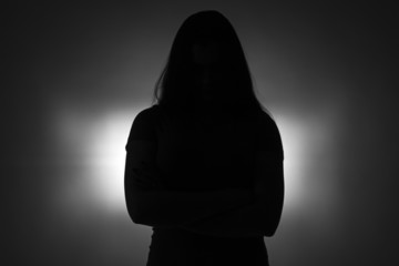 Silhouette of young  girl with arms crossed