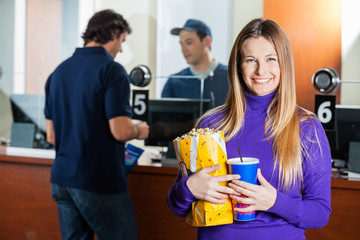 Woman Holding Snacks While Man Buying Tickets At Box Office