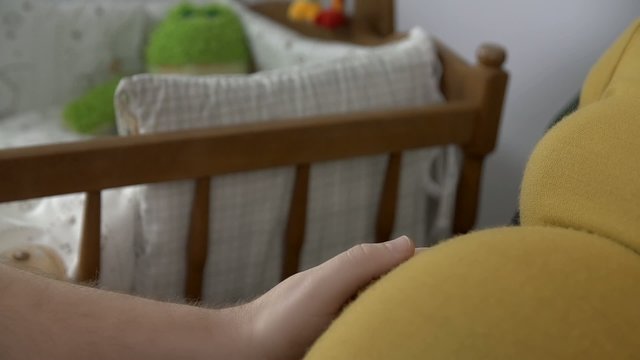 Male hand strokes pregnant belly