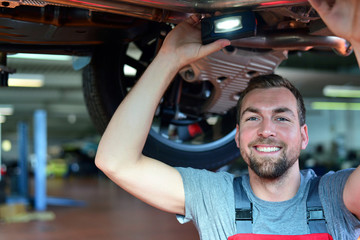 erfolgreicher KFZ Mechaniker in einer Autowerkstatt