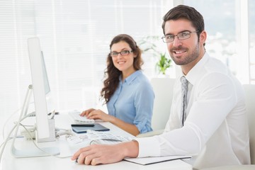 Portrait of smiling team with glasses at desk