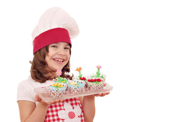 happy little girl cook with sweet muffins