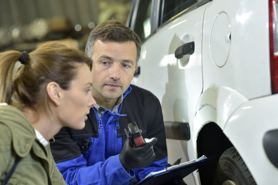Mechanician with insurance adjuster checking on auto repair
