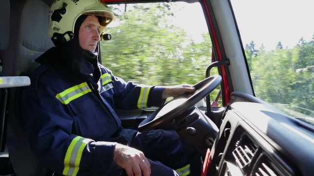 Fireman in full gear driving a firetruck