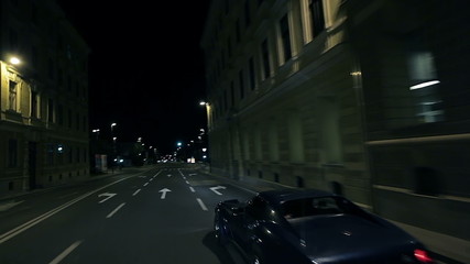 Beautiful diagonal shot of blue car overtaking at the city night ride