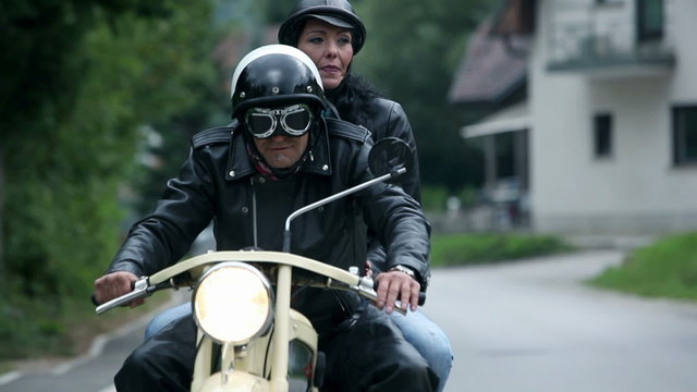 Close up on old motorcycle while driving and couple enjoying the ride