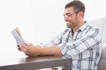 A smiling man reading a book