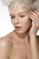 blond model applying a scrub treatment on the body an face