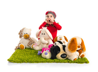 Surprised little girl playing with stuffed animals