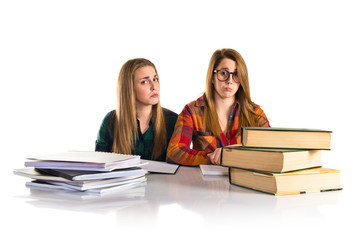 Sad sisters studying together